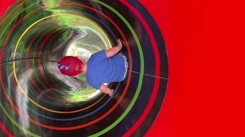 Boy sliding down the colourful pipe slide. Copyspace Stock Footage 158300206