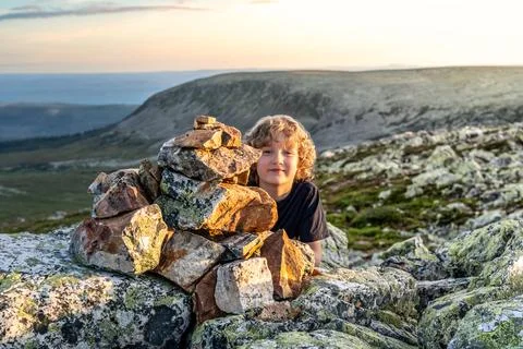 Boy Smiles by Stone Structure at Sunset on Sweden Lillnipen Nipfjället Mountain Stock Photos