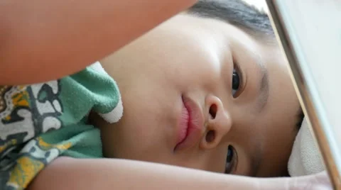 Boy smiling and looking a smart phone on bed with happy, Stockbeeldmateriaal 64849717