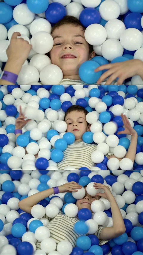  boy smiling and playing happily in a colorful blue and white ball Stock-Footage 342191325