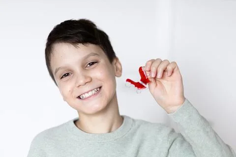 Boy smiling with tooth retainers in hand. Concept of crooked teeth correction Stock Photos