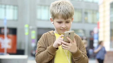 Boy sms texting using app on smart phone in city.  Stock Footage 77845244