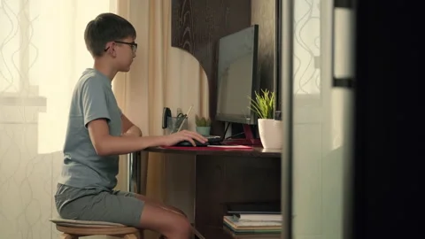 A boy solves interactive exercises using a computer at home while sitting at a Stock Footage 236639732