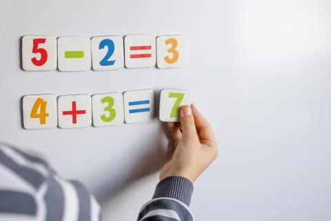 The boy solves mathematical examples. A child solves examples on a blackboard Stock Photos