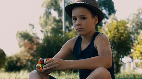Boy Solving A Rubik's Cube Puzzle. Smart Boy Tries To Finish Solving Stock Footage 116046524