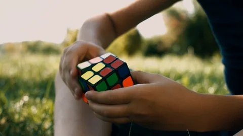 Boy Solving A Rubik's Cube Puzzle. Smart Boy Tries To Finish Solving Stock Footage 116046616