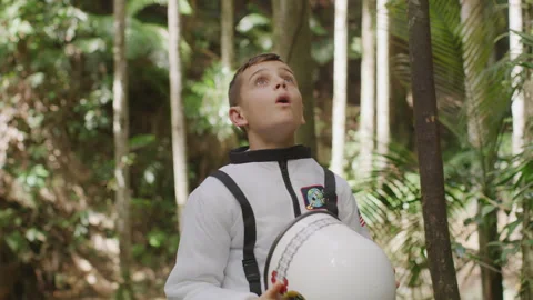 Boy in a Space Suit Costume walking somewhere in the jungle on an unknown p.. Stock Footage 264289301