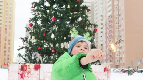 Boy with sparklers in front of the New Year tree and Christmas Видео 249241615