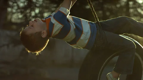 Boy spinning on tire swing Stock Footage