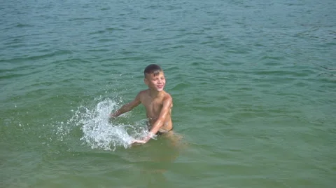 Boy splashing on the beach Stock Footage 65655050