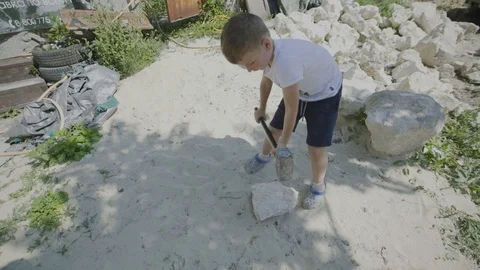 The boy is splitting stones by the sledgehammer Stock Footage 94346998