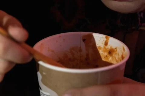 A boy spoons tomato soup - mashed potatoes in the dark. Close-up. Stock Photos