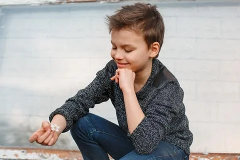Boy squatting and squinting Stock Photos