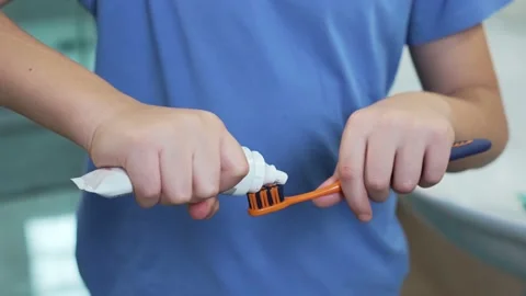 Boy squeezing toothpaste on brush Stock Footage 237668694