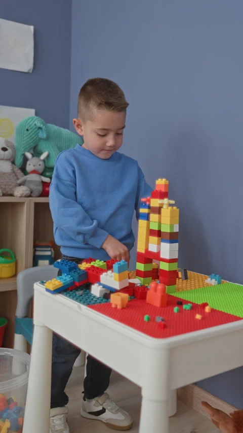 Boy stacking colorful blocks with hands on a play table inside a building p.. Stock Footage 339155040