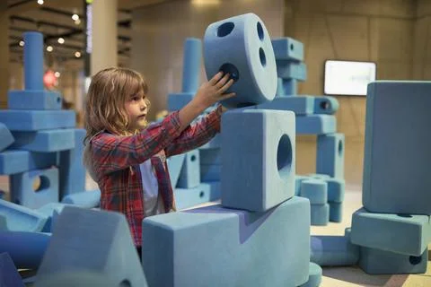 Boy stacking large pieces in science center Stock Photos