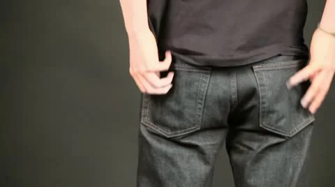 Boy stand in jeans at puts hand to pockets Stock Footage 12658904