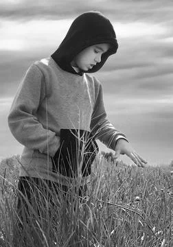 Boy standing and looking down at the fields. Stock Photos