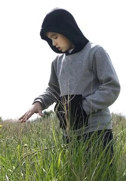 Boy standing and looking down at the fields. Stock Photos