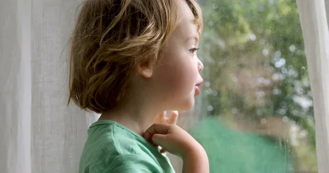 Boy is standing and looking out the window Stock Footage 111618117