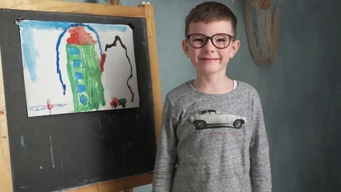 Boy standing beside his drawing Stock Footage 81473760