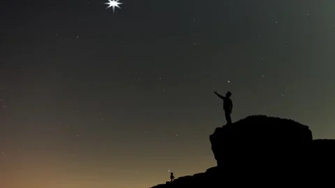 Boy standing on cliff pointing sky Stock Footage 259681624