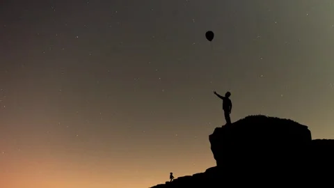 Boy standing on cliff pointing sky Stock Footage 260114831