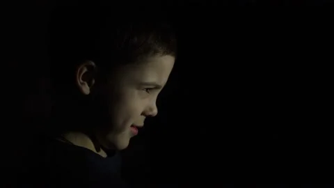 A boy is standing in the dark. Serious face 4K Video stock 126458266