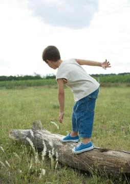 Boy standing on log Stock Photos