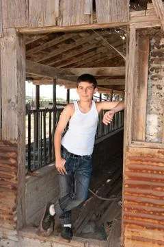 Boy standing at old barn Stock Photos