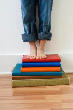 Boy standing on stack of books Stockfoto's