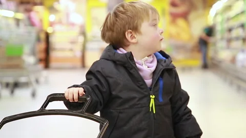 The boy is standing in the supermarket hall Stock Footage 166705908