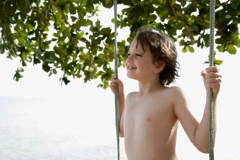Boy standing on swing Stock Photos
