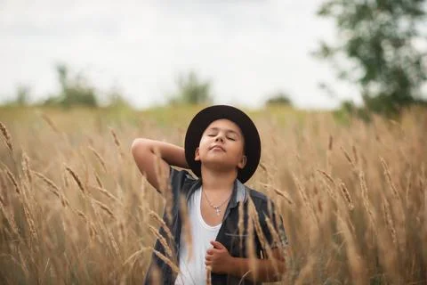 Boy standing in a tall grass field outdoors Foto stock