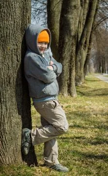 The boy is standing by the tree Foto stock
