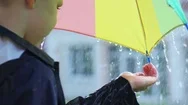 Boy Standing With Umbrella And Catching Raindrops Stock Footage