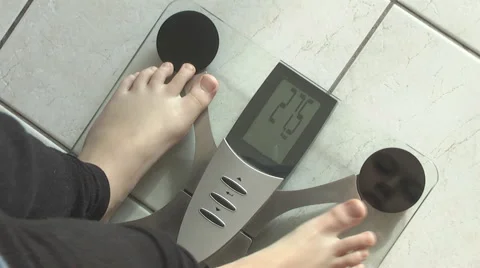 Boy, standing on weight scale Stock Footage 49083656