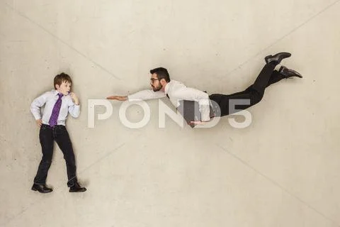 Boy standing while businessman flying Stock Photos