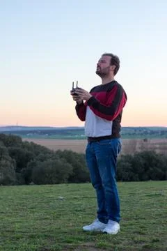 Boy standing while looking at the sky to control his drone Stock Photos