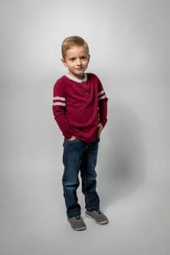 A Boy Standing on White Background with Hands in Pockets Foto stock