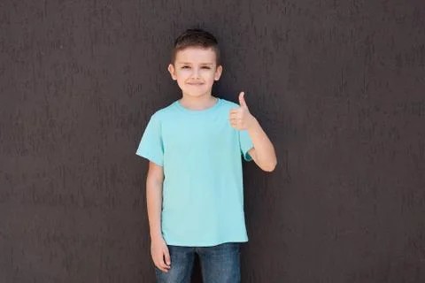 A boy  stands a  brown wall. Stock Photos