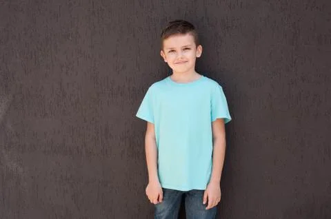 A boy  stands a  brown wall. Stock Photos