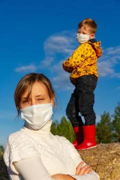 A boy stands on a haystack, his mother stands in front of him Stock Photos