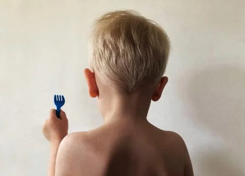 The boy stands with his back to the wall with a fork Stock Photos