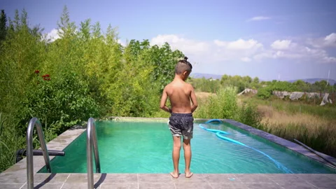 Boy Stands by Pool Before Jumping Into Water Stock Footage 345618395