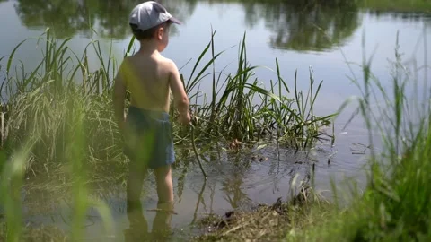 Boy stands in the river Stock Footage 133438617