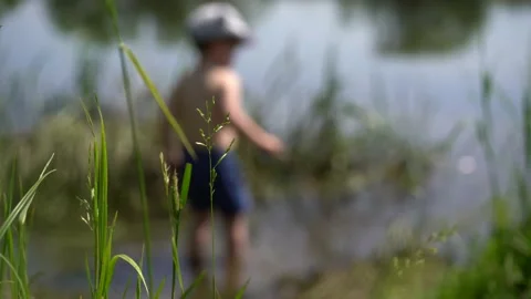 Boy stands in the river 스톡 동영상 133438657