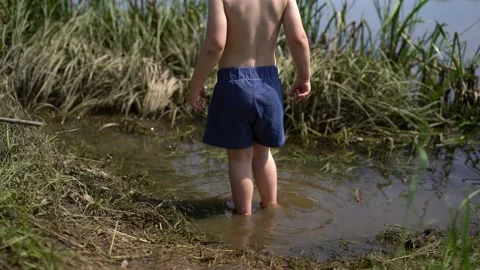 Boy stands in the river Stock Footage 133438909