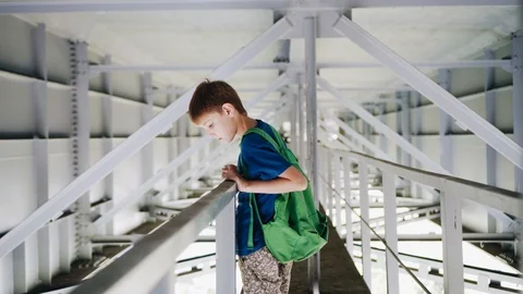 The boy stands under the bridge and look at the water. Walk under the bridge Stock Footage 113071687