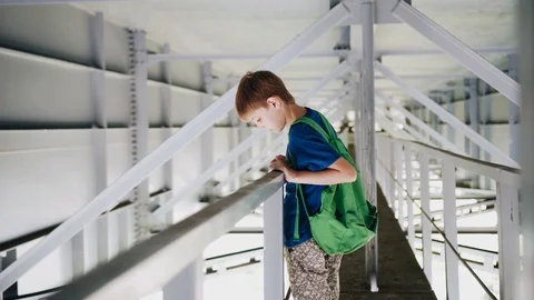 The boy stands under the bridge on the parapet and looks down Video stock 113071692